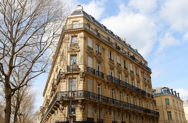 A fachada de uma casa tradicional francesa com varandas e janelas típicas de Paris, França