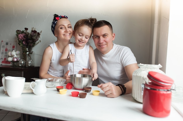 A família cozinha biscoitos na cozinha