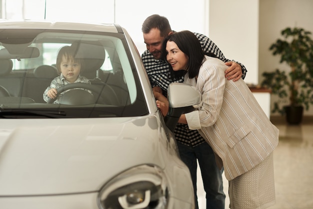 Foto a família está considerando o interior de seu futuro carro.