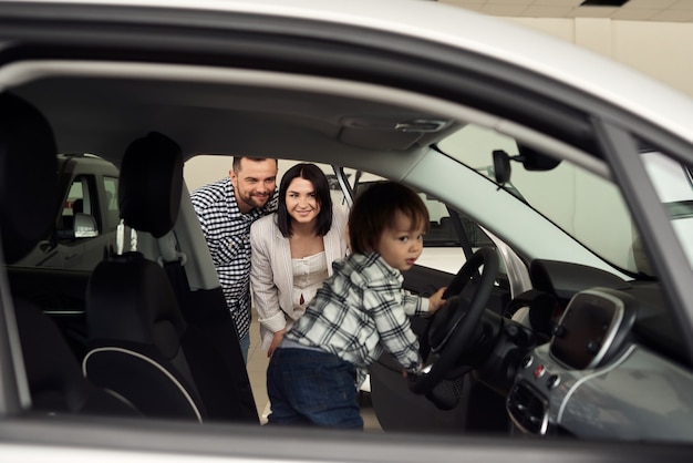 Foto a família está considerando o interior de seu futuro carro.