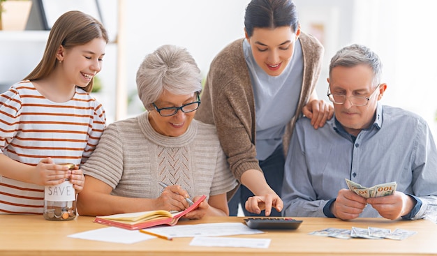 A família está sentada em uma mesa com um recibo de papel e calculando despesas, administrando o orçamento.