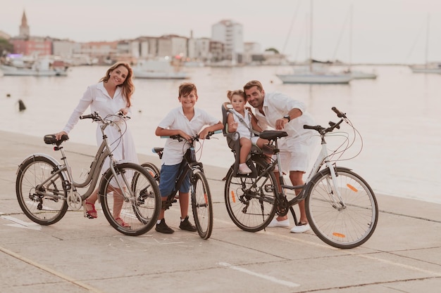 A família feliz desfruta de uma bela manhã à beira-mar andando de bicicleta juntos e passando tempo juntos