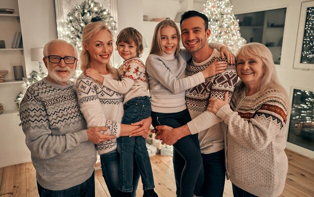 A família feliz em pé perto da árvore de natal