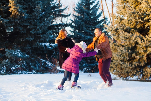 A família feliz enquanto caminha no parque de inverno