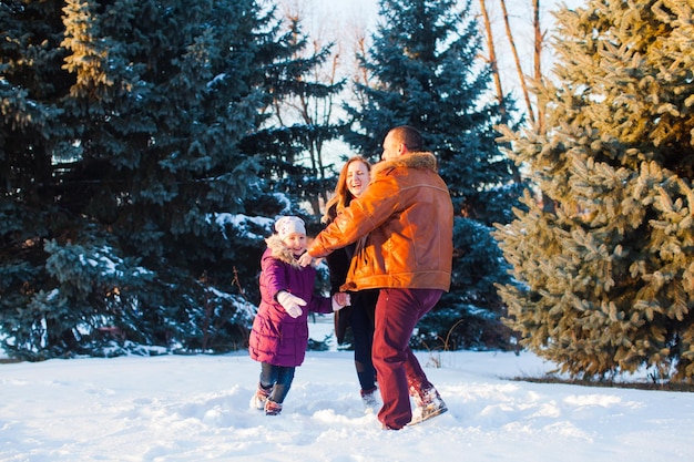 A família feliz se divertindo ao ar livre no inverno