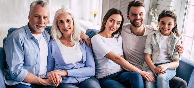 Foto a família feliz sentada no sofá