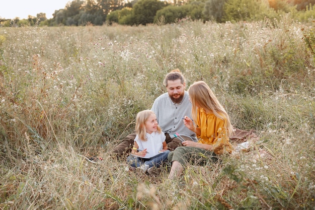 A família no piquenique da caminhada está feliz junto. valores de família