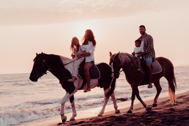 A família passa o tempo com seus filhos enquanto cavalgam juntos em uma praia arenosa. Foco seletivo. foto de alta qualidade