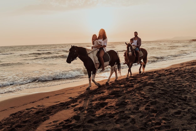 A família passa o tempo com seus filhos enquanto cavalgam juntos em uma praia arenosa. Foco seletivo. foto de alta qualidade
