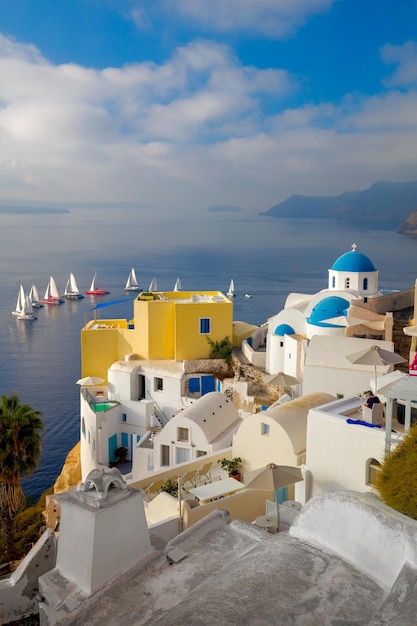 A famosa vista dos pontos turísticos de Santorini casas brancas cúpulas azuis e iates no mar azul Ilha Santorini Grécia Europa