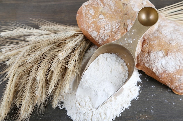 A farinha integral em scoop em mesa de madeira