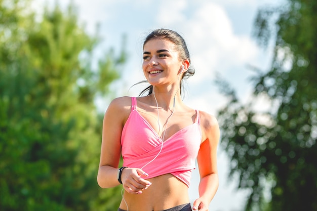 A feliz desportista correndo com fones de ouvido