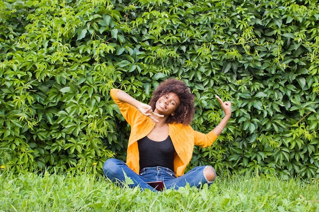 A feliz e jovem afro-americana na rua se divertindo