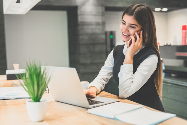 A feliz empresária telefona para a área de trabalho