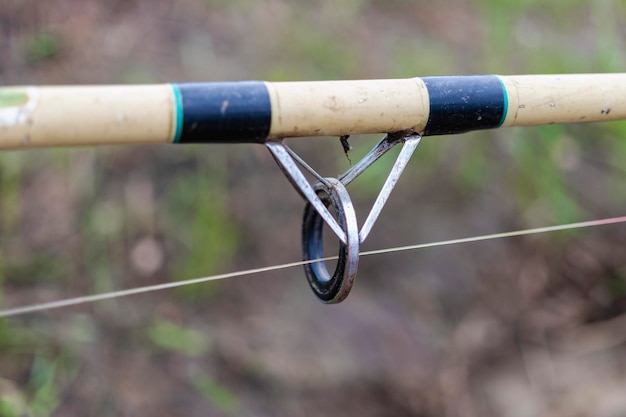 Foto a fiação de pesca está na grama pesca com um carretel de fiação closeup de equipamento de pesca