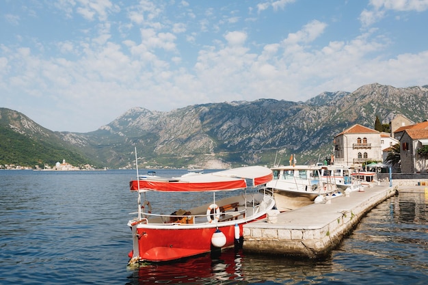 A fila de barcos está atracada no píer da baía de kotor, na costa de perast montenegro