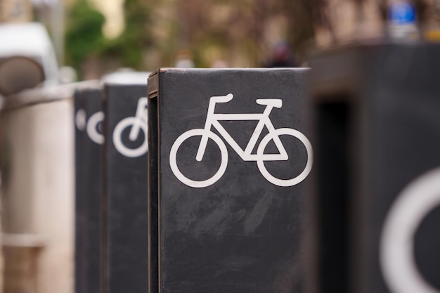 A fileira de racks metálicos de estacionamento de bicicletas com ícones de bicicleta instalados na cidade