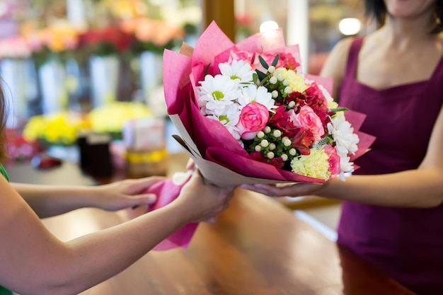 A florista dará ao cliente um lindo buquê de flores