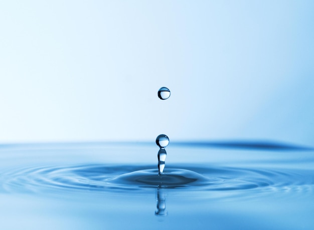 A fonte da vida Foto de estúdio abstrata de uma gota de água caindo em uma poça de água