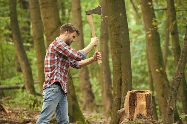 A força é necessária para sobreviver no conceito de natureza selvagem homem com machado no cortador de floresta indo cortar lenhador segurando machado nas mãos desejo de viajar caminhadas e viajar cortador de árvores com machado