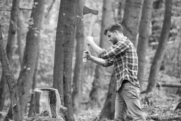 A força é necessária para sobreviver no conceito de natureza selvagem homem com machado no cortador de floresta indo cortar lenhador segurando machado nas mãos desejo de viajar caminhadas e viajar cortador de árvores com machado