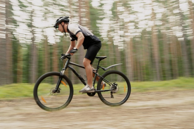 A foto em movimento está desfocada Um ciclista andando de bicicleta com capacete usando uma atividade de GPS