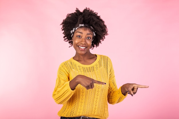 A foto horizontal agradou mulheres de pele escura com corte de cabelo, aponta para a direita com os dois dedos