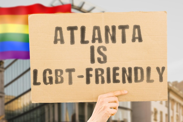 A frase "Atlanta é LGBT-Friendly" em um banner na mão dos homens com bandeira LGBT borrada no fundo. Relações humanas. diferente. Diversos. liberdade. Sexualidade. Problemas sociais. Sociedade
