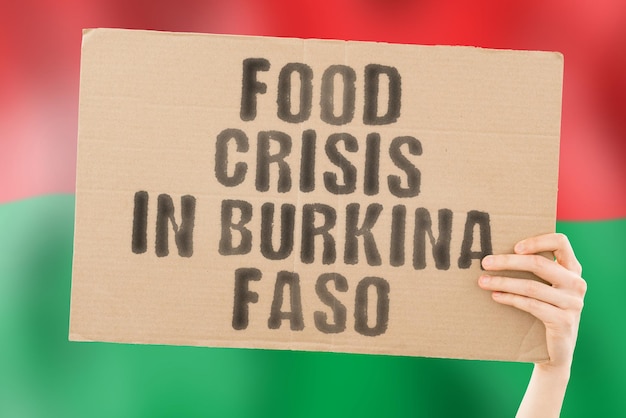 Foto a frase crise alimentar em burkino faso está em um banner nas mãos dos homens com um fundo desfocado crise finanças vida nutrição pão desastre colapso questão social problema