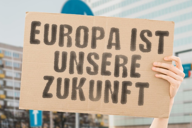 A frase Europa é o nosso futuro está em uma faixa nas mãos dos homens com fundo desfocado Ativismo Protesto Comício Marcha Demonstração Greve Resistência Vozes Pessoas Sociedade Cultura Identidade