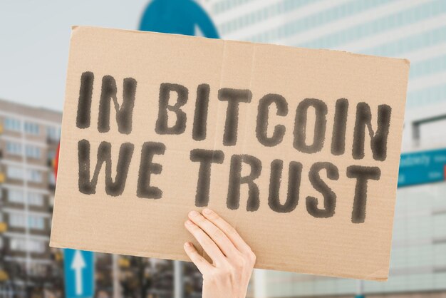 A frase In Bitcoin we trust está em um banner nas mãos de homens com fundo desfocado Code Data