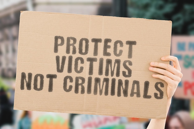 A frase Proteja as vítimas não os criminosos em um banner na mão dos homens Crime Violência Medo Seguro