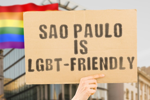 A frase "São Paulo é LGBT-Friendly" em um banner na mão dos homens com bandeira LGBT borrada ao fundo. Relações humanas. diferente. Diversos. liberdade. Sexualidade. Problemas sociais. Sociedade