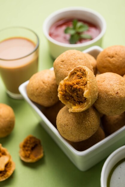 Foto a fruta seca kachori é uma bola pequena e redonda recheada com masala e caju etc, servida com ketchup de tomate e chá quente, produto haldiram