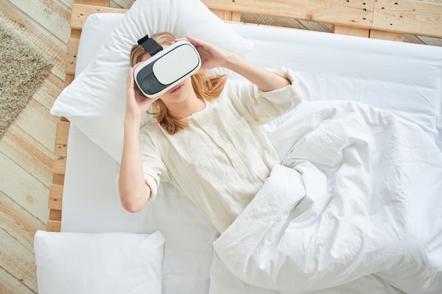 A garota com o capacete de realidade virtual na cama