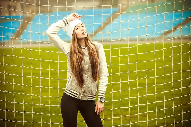 A garota corre e entra para praticar esportes no estádio