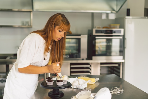 A garota da confeitaria está preparando um conceito de cupcakes ingredientes para cozinhar produtos de farinha ou sobremesa