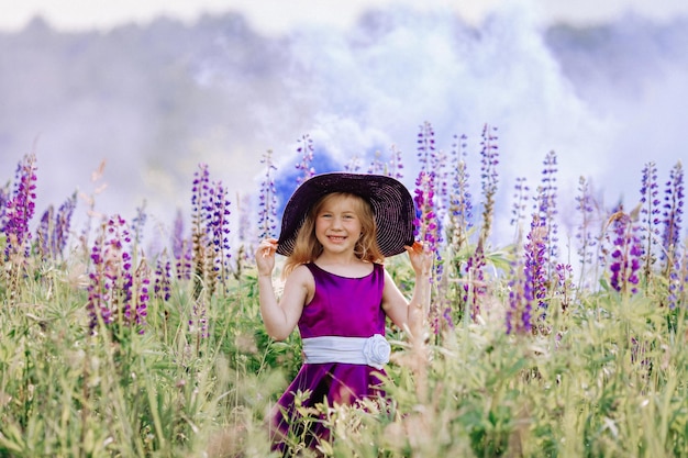 A garota de chapéu caminha em um campo de tremoços.