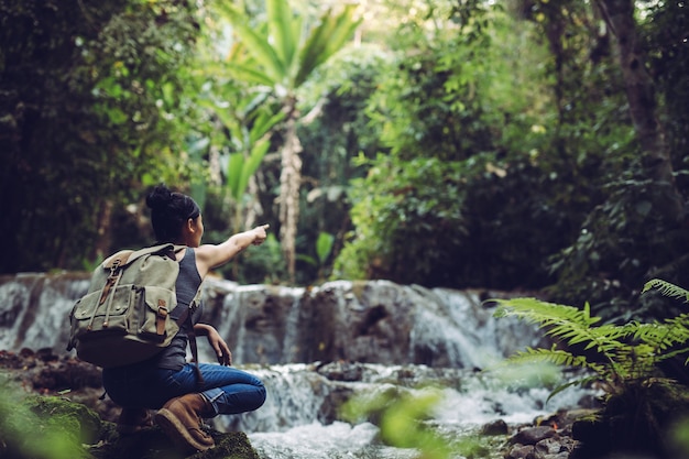 A garota é refrescante em riachos na floresta tropical.