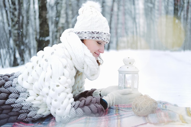 A garota encontra-se na neve na floresta de inverno ou no conceito de parque, férias e feriados de natal