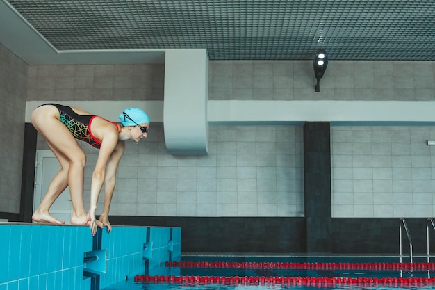 A garota está envolvida em nado sincronizado na piscina Truque de salto na piscina O nadador pula na piscina