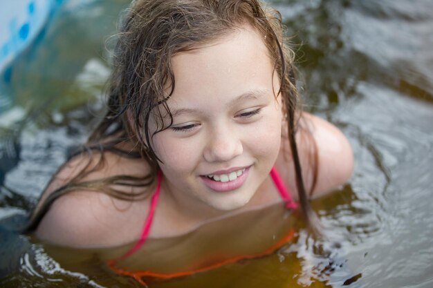 A garota está rindo na piscina no dia de verão