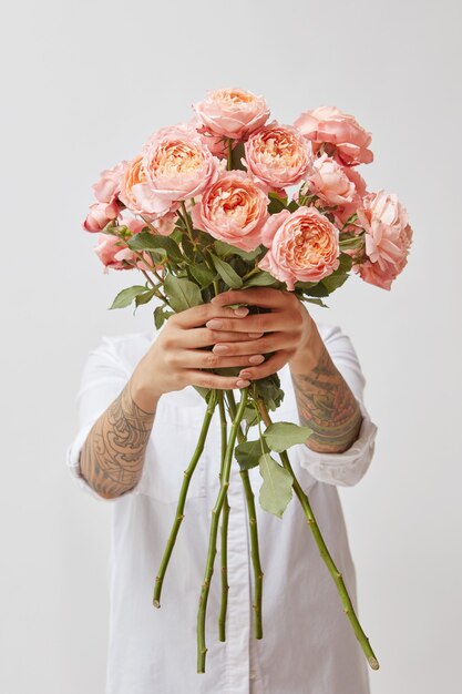 A garota está segurando um buquê de rosas frescas