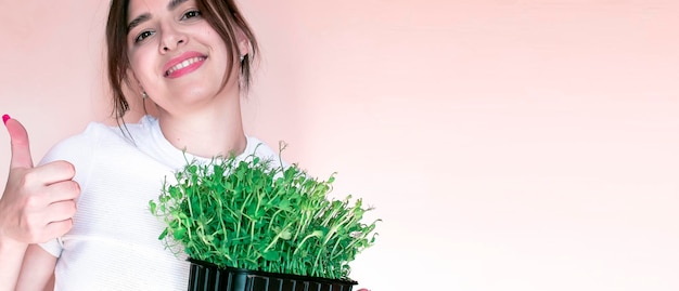 A garota está segurando uma caixa de papelão com microgreens Brotos crus Comida saudável e dieta estilo de vida vegano Ingrediente verde fresco folhas deliciosas comida biológica orgânica natural Sementes selecionadas para crescimento