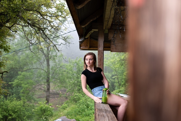 A garota está sentada em cima do muro.