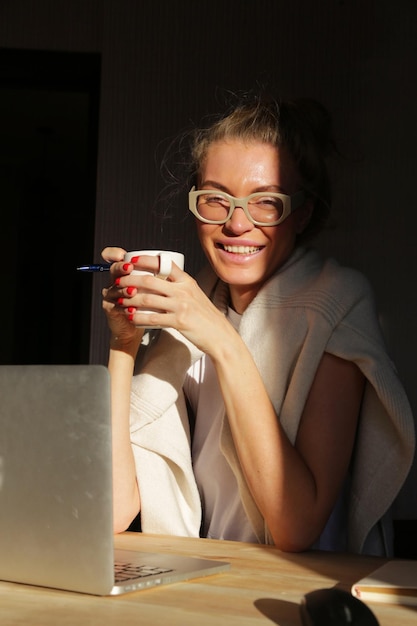 a garota está trabalhando em um laptop em casa