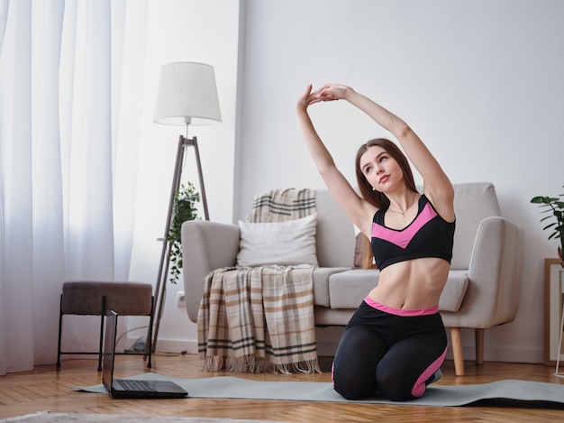 A garota faz alongamento em casa. fitness em casa