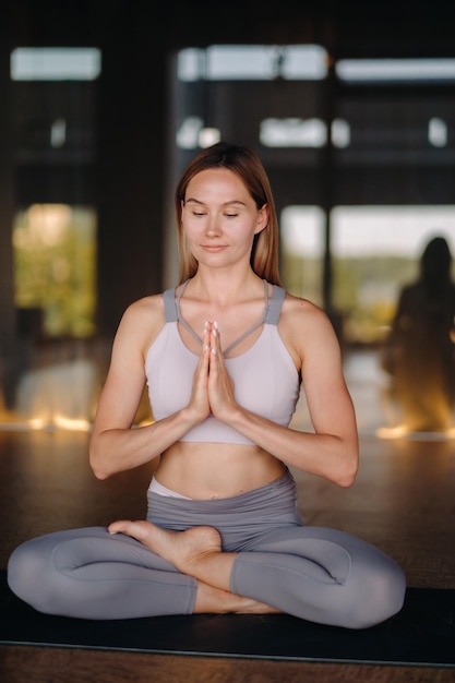 A garota faz ioga uma mulher em roupas esportivas faz exercícios de ioga na academia