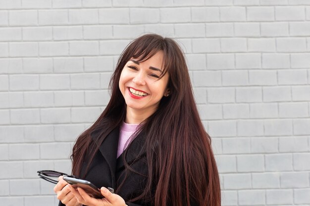 A garota feliz falando ao telefone na rua