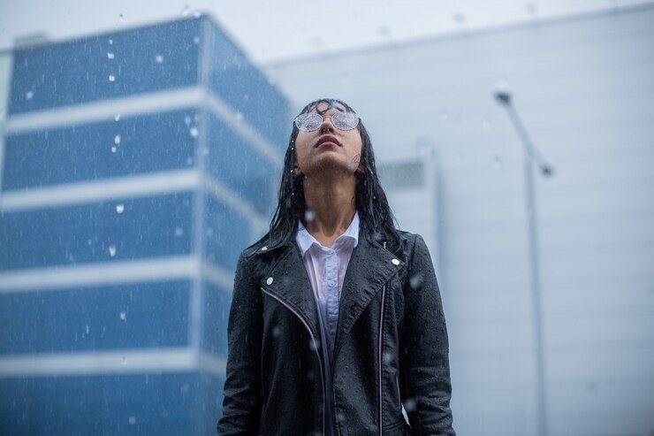 A garota fica imóvel na chuva.